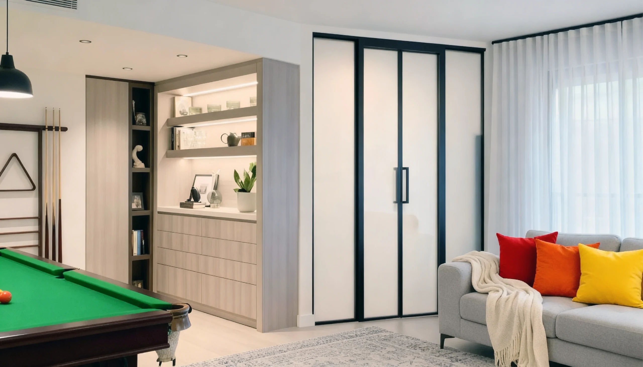 Komandor Lumi aluminum-framed glass partition and sliding door system featuring a black anodized architectural frame. This interior glazing system uses a bi-pass sliding mechanism with precision ball-bearing rollers and an integrated anti-jump safety feature for smooth, quiet operation. The panels incorporate frosted safety glass inserts, providing light diffusion and privacy. The floor-to-ceiling configuration demonstrates the millimeter-precise customization of the Lumi system, utilizing a low-profile bottom track and reinforced aluminum profiles for maximum structural rigidity in residential room division.