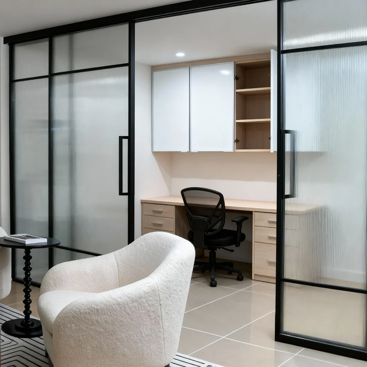 Komandor Lumi aluminum-framed interior glazing system featuring a fixed glass screen and integrated swing door partition. This architectural solution utilizes slim-profile anodized aluminum frames to secure fluted architectural glass inserts, providing a modern alternative to traditional drywall. The system is custom-manufactured to the millimeter, incorporating a header-mounted track for stability and precision-engineered hinges for a seamless, quiet operation. This high-end partition maximizes natural light flow while defining distinct zones within a residential space.