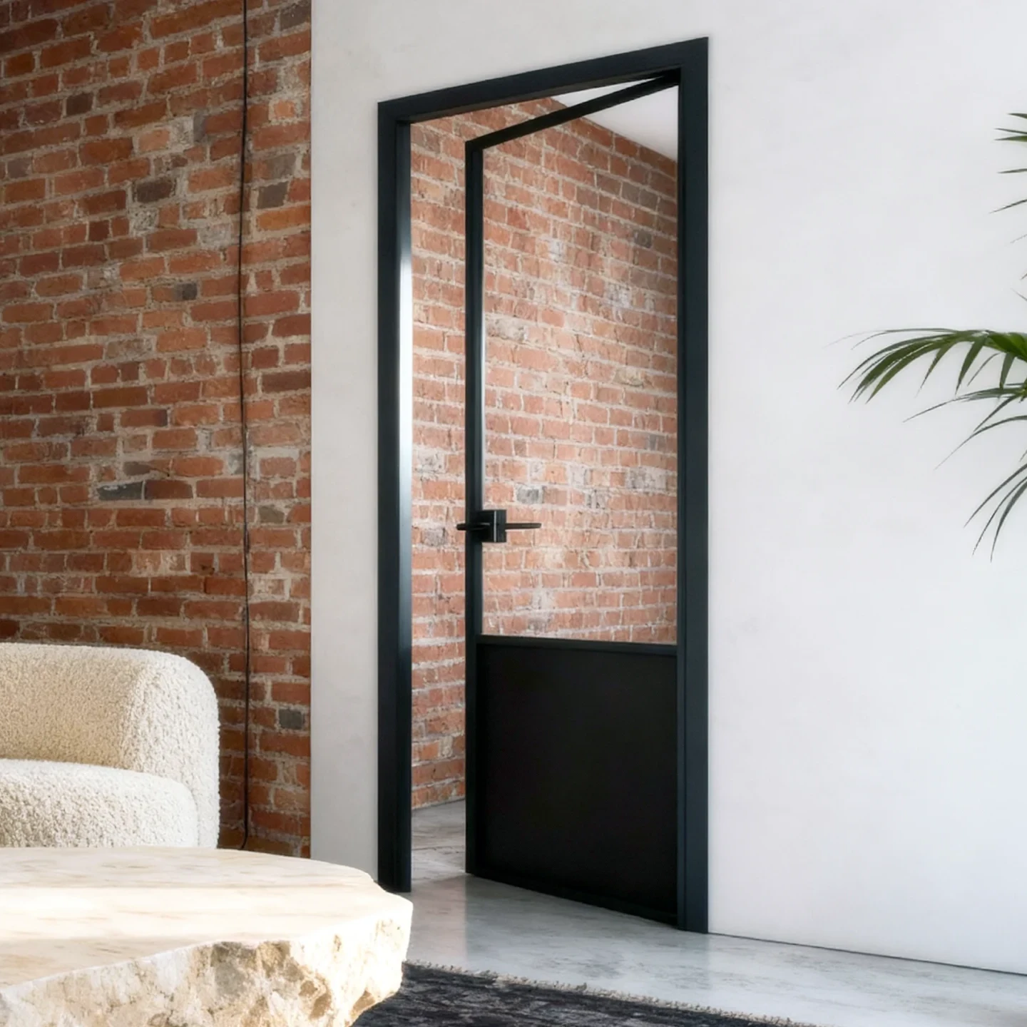 Komandor Lumi aluminum-framed swing door system featuring a modern charcoal black finish and clear safety glass insert. This custom interior glazing solution utilizes high-grade 6063-T5 anodized aluminum for structural rigidity and a slim visual profile. The door is precision-engineered to the millimeter, incorporating a matte black architectural handle and a bottom kick-plate panel. Designed for luxury Toronto residential and commercial interiors, it offers a sophisticated, durable alternative to standard wood doors, featuring maintenance-free mechanisms that never require oiling.