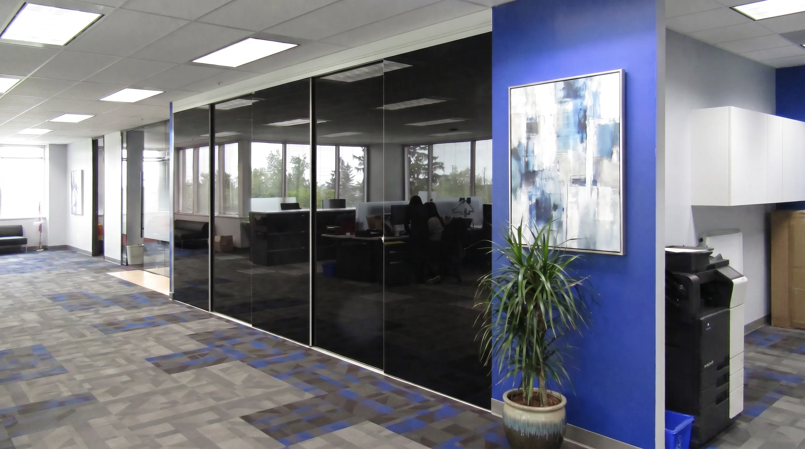 Tinted glass sliding office partition on a concealed aluminum track by Komandor
